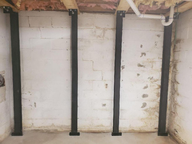 Steel force beams to stabilize a basement wall that was leaning under soil pressure on a home in Western North Carolina of North Carolina.