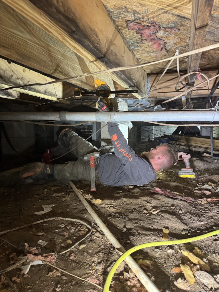 A WNC technician sistering a damaged floor joist in a upstate crawlspace.