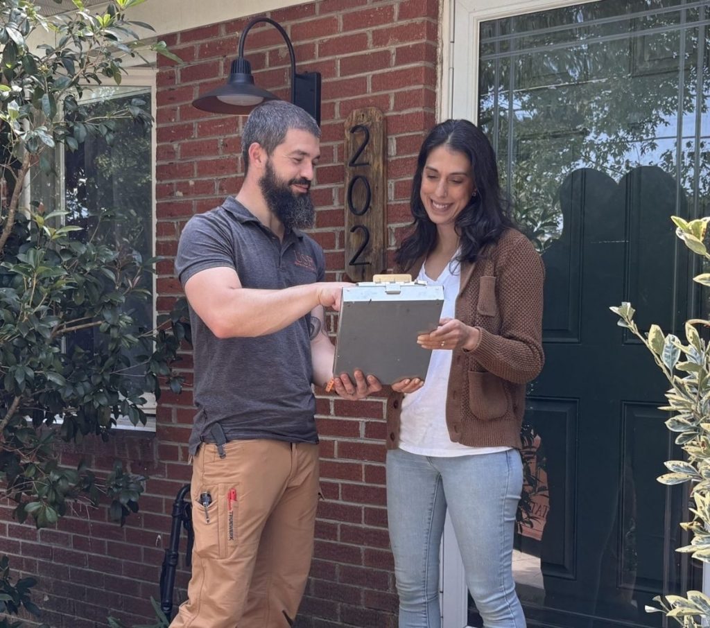 a happy customer reviewing an estimate with WNC on their front porch.